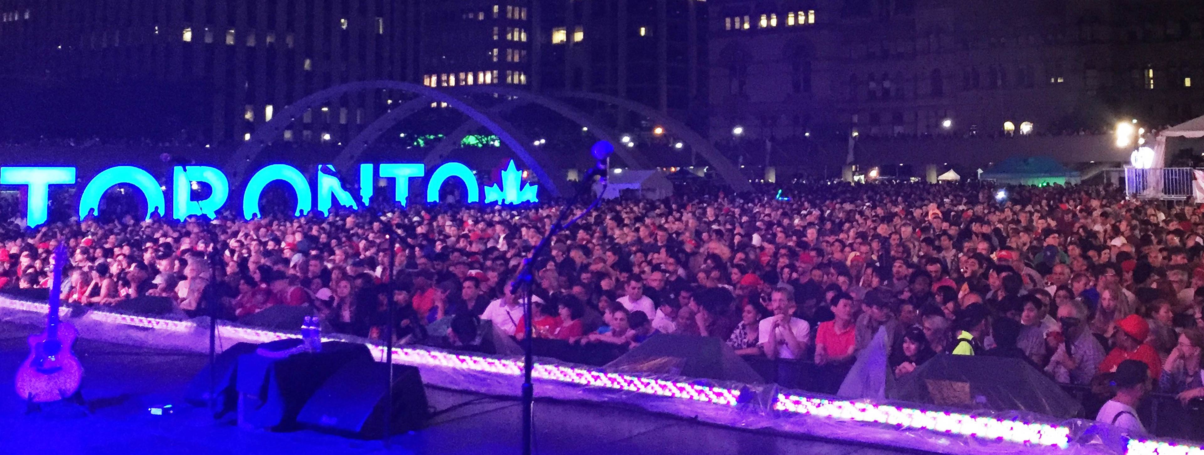 Une foule assiste à un concert extérieur à Toronto durant la fête du Canada.